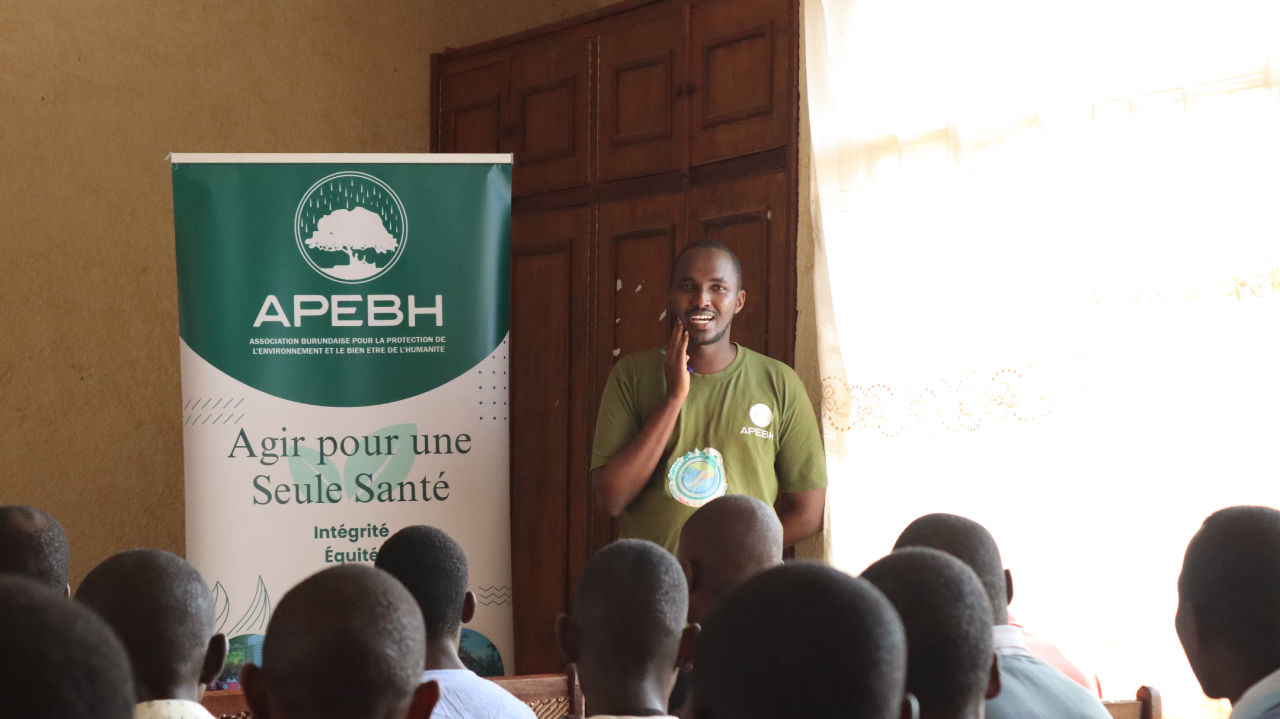 Un animateur présente le projet devant une bannière APEBH à Kirundo.